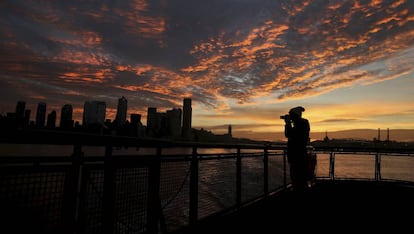 Una mujer fotografía el atardecer en Seattle (Estados Unidos), ejemplo de ciudad global gracias al empuje de las grandes empresas tecnológicas.