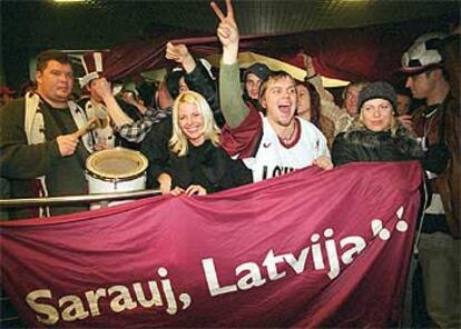 Aficionados letones, recibiendo ayer a su selección en el aeropuerto de Riga.