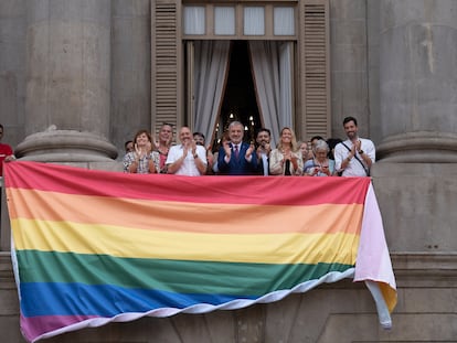 El alcalde de Barcelona, Jaume Collboni, y parte de su equipo, este miércoles tras una bandera LGTBI colocada en el Ayuntamiento.