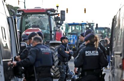 Los Mossos d'Esquadra junto a los tractores que bloquean la entrada a Mercabarna, este martes.