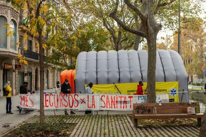 Aspecto de la carpa montada frente al centro de salud Passeig Sant Joan de Barcelona para realizar PCR, este martes, con una pancarta que reclama más recursos para la sanidad.