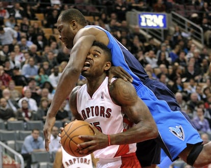 Elton Brand, de los Mavericks, intenta frenar a Amir Johnson, de los Raptors.