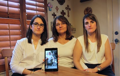 Dennysse Vadell sits between her daughters Veronica, right, and Cristina, Feb. 15, 2019, in Katy, Texas, while holding a digital photo of father and husband Tomeu Vandell, who was jailed in Venezuela at the time.