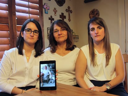 Dennysse Vadell sits between her daughters Veronica, right, and Cristina, Feb. 15, 2019, in Katy, Texas, while holding a digital photo of father and husband Tomeu Vandell, who was jailed in Venezuela at the time.