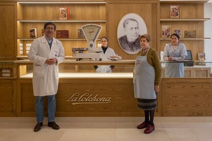 Los tres hermanos Fernández, Santiago, Remedios y Victoria, la quinta generación al frente del obrador La Colchona, en Estepa (Sevilla). Con delantal, su madre Victoria Alfaro.