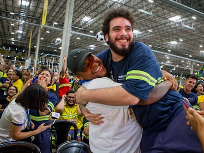 Two men celebrate a Brazil goal at a Mercado Libre distribution center.