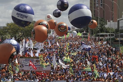 Milhares de manifestantes com balões, cartazes e bandeiras se reúnem em Brasília.