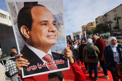 A person carries a picture of Egyptian President Abdel Fattah El-Sisi on the first day of the presidential election in Cairo, Egypt, December 10, 2023.