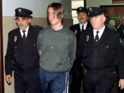 El joven, custodiado por agentes de la Policía tras ser detenido en Murcia en 2000.
