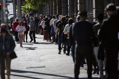 Una larga cola de gente espera para votar en el colegio Santa María, en la calle Ronda de Toledo, del centro de la capital.