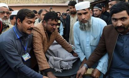 Un grupo de paquistaníes transportan a una víctima del atentado suicida de este martes en la ciudad de Mardan.