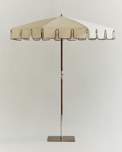 Las sombrillas están viviendo un renacimiento discreto pero sofisticado, impulsado por el auge del diseño funcional, el lujo artesanal y la conciencia estética en torno al sol. En la imagen, sombrilla reclinable con acabado en ondas de Zara Home.