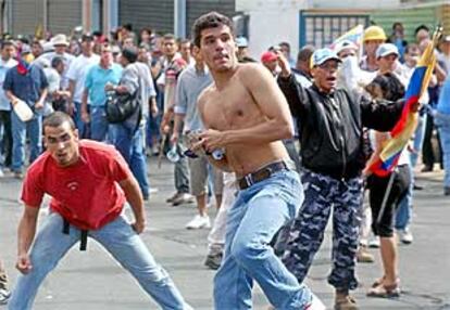 Dos jóvenes, durante los enfrentamientos registrados la tarde de ayer (esta madrugada en España) en Caracas.