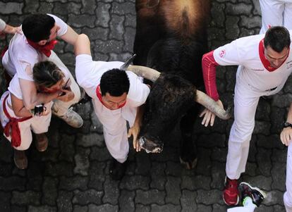 Un toro de la ganadería Fuente Ymbro corre entre los participantes del primer encierro de San Fermín.