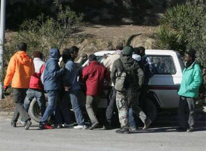 Un grupo de inmigrantes se abalanza sobre el vehículo de un empresario agrícola para ser contratados en Baena (Córdoba).