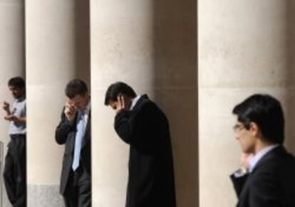 Empleados de la City londinense, en las afueras de Paternoster Square.