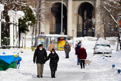 Ciudadanos caminan por una calle nevada de Madrid, este lunes.