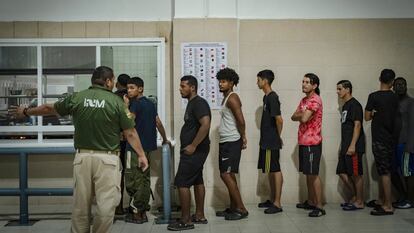 Un grupo de migrantes retenidos en la estación migratoria de Tapachula (Chiapas) hace fila para recibir sus alimentos.