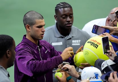 Alcaraz firma autógrafos a los aficionados en la pista Arthur Ashe de Nueva York.