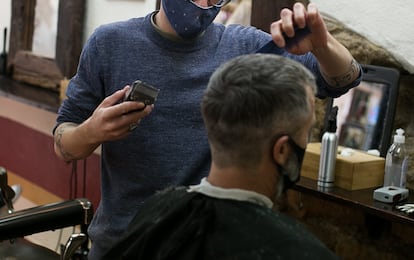 Un peluquero corta el pelo a un cliente, en una imagen de archivo.