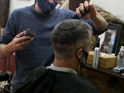 Un peluquero corta el pelo a un cliente, en una imagen de archivo.