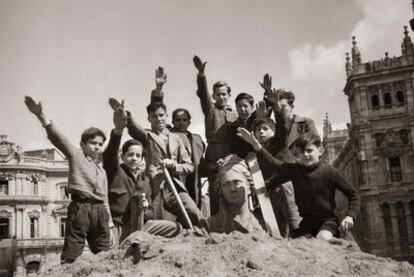Niños saludando con el brazo en alto sobre la estatua de Cibeles en marzo de 1939.