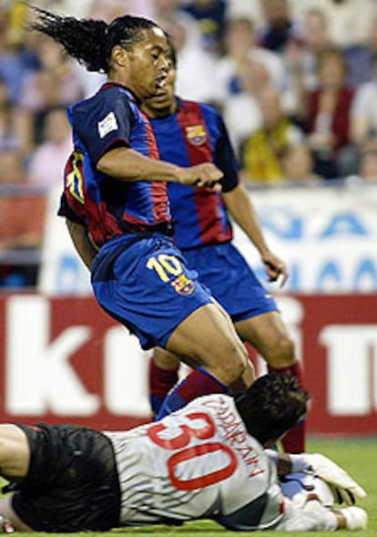 Zaparain, portero del Zaragoza, detiene el balón, acosado por Ronaldinho.