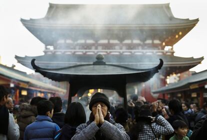 Un hombre reza fuera del templo Sensoji antes de las vacaciones de Año Nuevo en Tokio (Japón).