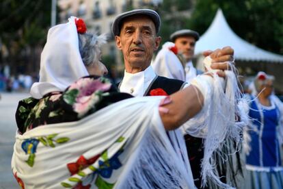Dos personas bailan el 'chotis' vestidas con el traje tradicional madrileño de "chulapos" durante la fiesta de la Virgen de La Paloma, en Madrid.