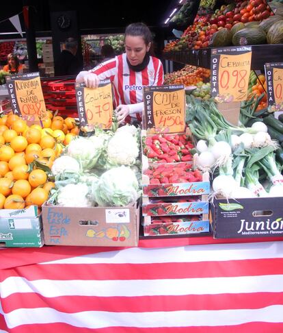 La empleada de una fruteria ataviada con la camiseta del Athletic.