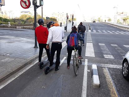 Varios usuarios de bicicletas y patinetes circulan por un carril bici en Valencia.