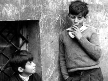 Un ni&ntilde;o observa a otro que exhibe una actitud de suficiencia con el cigarrillo. 