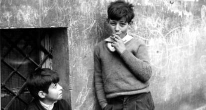 Un ni&ntilde;o observa a otro que exhibe una actitud de suficiencia con el cigarrillo. 