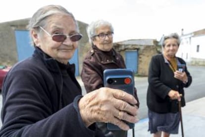 Three residents show the mobile device with the red emergency button.