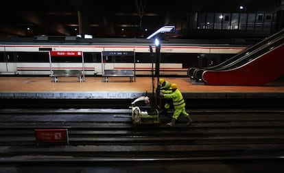 El mantenimiento de la infraestructura ferroviaria se realiza de madrugada para que no se interrumpa el servicio de viajeros de primera hora. En esta imagen dos operarios en la estación de Atocha.
