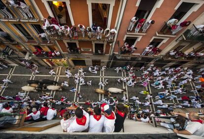 El público presencia desde los balcones el séptimo enciero de sanfermines en Pamplona.