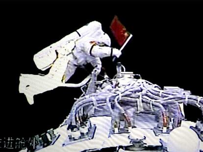El pionero cosmonauta Zhigang enarbola la bandera de su país.