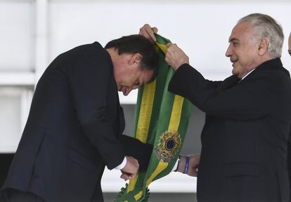 El presidente saliente de Brasil, Michel Temer, entrega la banda presidencial al nuevo presidente, Jair Bolsonaro, en Brasilia.