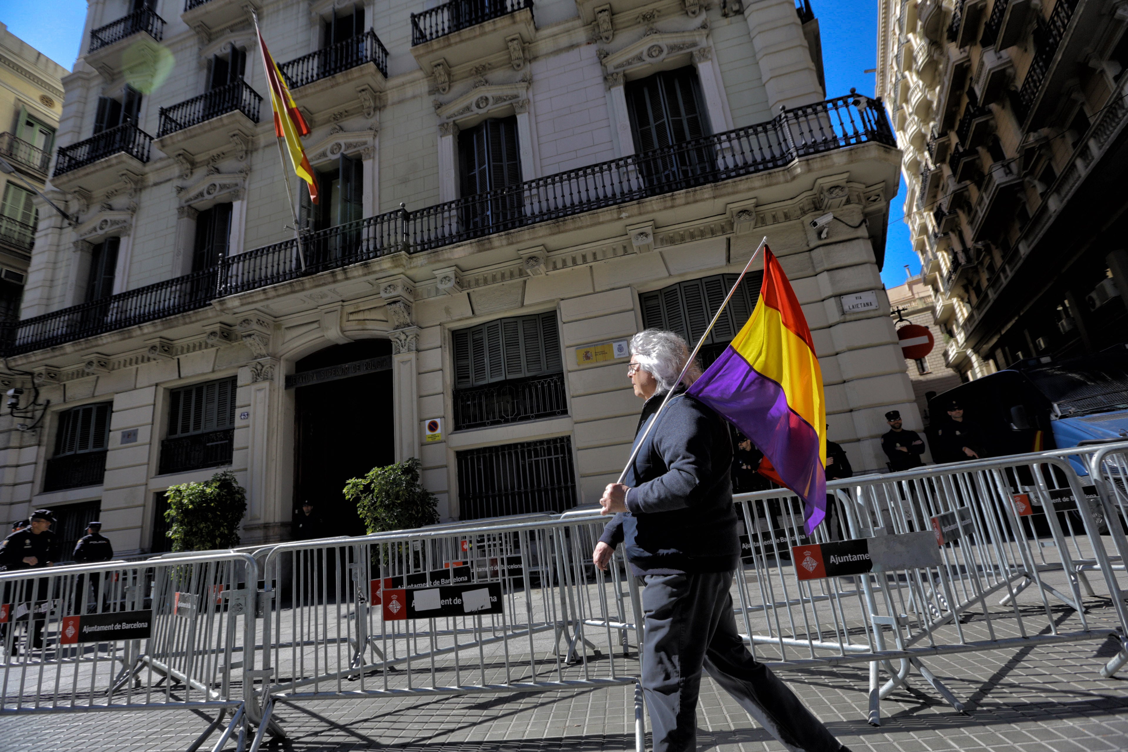 Una persona con una bandera republicana pasa por delante de la Jefatura Superior de Policía de Cataluña en Via Laietana de Barcelona, en una imagen de archivo.