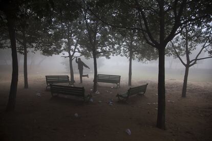 Un hombre practica hace deporte en un parque cubierto de niebla en Nueva Delhi, India