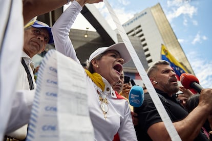 Una mujer muestra el acta de recuento de votos de su sesión electoral en la que Edmundo González sale victorioso durante una manifiestación en Caracas, el 30 de julio.