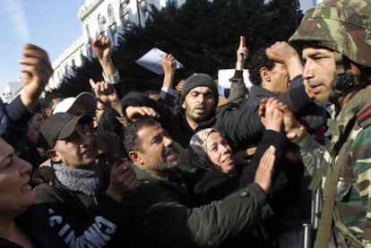 Varios manifestantes opuestos al régimen de Ben Ali saludan a un soldado, ayer en Túnez capital.