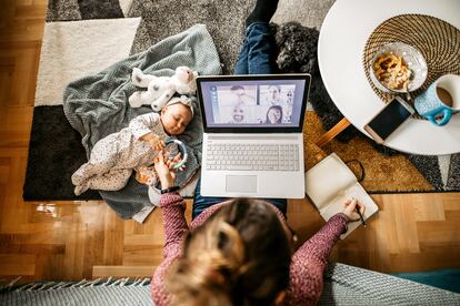 Una madre trabaja mientras cuida de su bebé