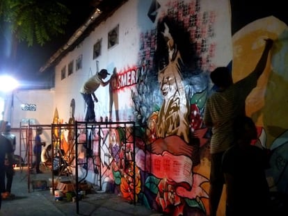 El artista urbano indonesio X-Go, en un momento de la elaboración de un mural, en el kampung Pandean de Surabaya, con su colectivo: Serikat Mural Union, en 2014.