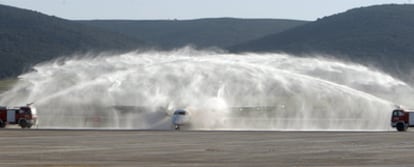 Dos camiones de bomberos bautizan el primer avión que operó en el aeropuerto Central de Ciudad Real.