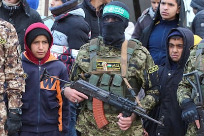 Miembros de Hamas hacen guardia mientras un grupo de simpatizantes se reúne con ocasión de la entrega de rehenes del pasado sábado.