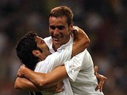 Figo (izda.) y Helguera se abrazan tras conseguir este su gol.