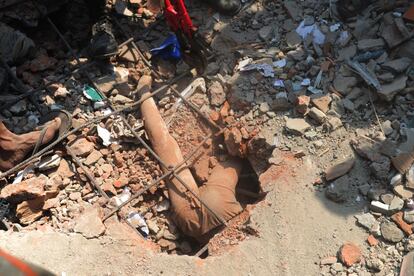 El cuerpo sin vida de un niño, se encuentra atrapado, en el edificio de ocho plantas derrumbado en Dacca (Bangladesh).