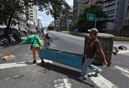 Dos jóvenes bloquean una de las calles próximas al palacio presidencial, en Caracas.