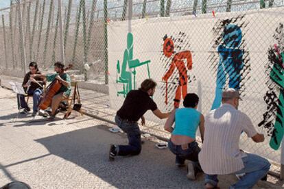 Participantes en el acto celebrado junto a la valla de Melilla, en memoria de los inmigrantes fallecidos hace un año.